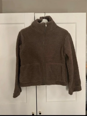 Brun teddyjacka med dragkedja - Mysig brun teddyjacka från Lager 157 i storlek XS. Jackan har hög krage, hel dragkedja framtill och två stora fickor. Oanvänd med prislapp kvar💕