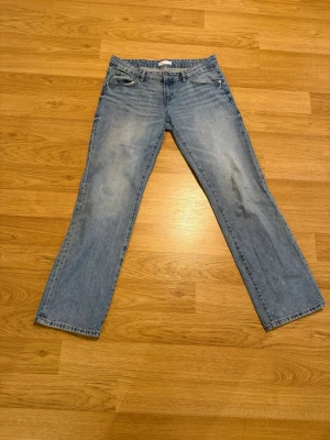 Blå raka jeans från Perfect Jeans - Säljer ett par klassiska blå jeans från Perfect Jeans i rak modell. Jeansen har fem fickor, bälteshällor och snyggt slitna detaljer framtill. Tillverkade i denim med ljus tvätt och silverfärgad knapp. Perfekta till en avslappnad stil.