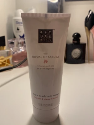 Rituals The Ritual of Sakura Body Cream - Lyxig body cream från Rituals i serien The Ritual of Sakura. Innehåller risextrakt och körsbärsblomma som ger en mjuk och återfuktad känsla. Vit tub med elegant design, 100 ml men har använt hälften så man kan säga att det är 55 ml kvar.Perfekt för dig som vill ha en fräsch och blommig doft på huden.
