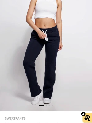 Mörkblå raka mjukisbyxor - Mörkblå mjukisbyxor med raka ben och vit dragsko i midjan. Byxorna har en enkel och clean design utan synliga loggor, perfekta för en avslappnad stil. Tillverkade i mjukt och bekvämt material som passar för chill dagar.