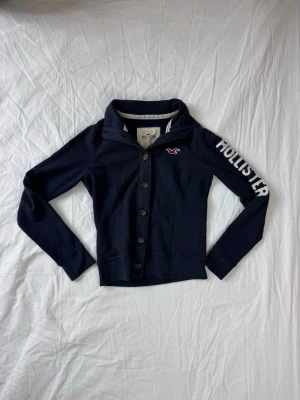 Marinblå kofta från Hollister - Säljer nu en Hollister Kofta👕                                                              Storlek: M (Unisex så att den passar XS), Skick: 9/10, Skriv vid minsta fråga, Fraktar alltid inom 24h efter köp📦