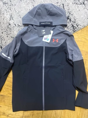 Under Armour vindjacka (läs under!) - Säljer för att jag köpte fel storlek, alla tags är på den kmr med papperpåsen, org påsen, kvitto allt kommer med. Storlek Barn M. Passar 135cm-150cm, 11-12år.