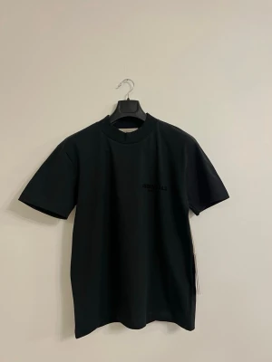 Essentials Fear of God T-shirt – svart  xs - Helt ny Essentials Fear of God t-shirt i svart färg. Design med Essentials-logga på bröstet. Perfekt för både vardag och streetwear. Finns i storlek xs men passar också S