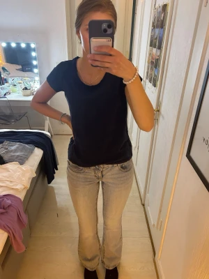 Ljusblåa bootcut jeans  - Säljer ett par ljusblåa lågmidjade bootcut jeans med snygga detaljer på bakfickorna med knappar. Storlek 38 men tror även de passar som 36 då jag brukar ha det på Gina jeans. Endast använda fåtal gånger!🥰🥰