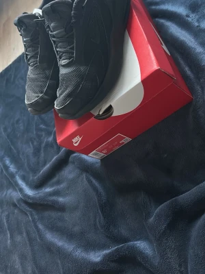 Nike Air Max 71,5 svarta sneakers - Svarta Nike Air Max 71,5 sneakers med chunky sula och meshdetaljer. Snygg design med diskret Nike-logga på sidan och AIR-text bak på hälen. Skorna har klassisk snörning och är tillverkade i en mix av textil och syntetmaterial.