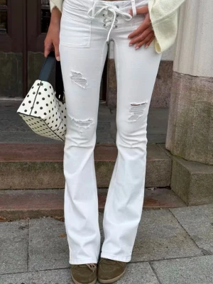Vita bootcut jeans med snörning - Vita skit snygga jeans från Gina tricot. Slutsålda och väldigt efterfrågade. Skriv gärna för mer information. I storlek m. 
