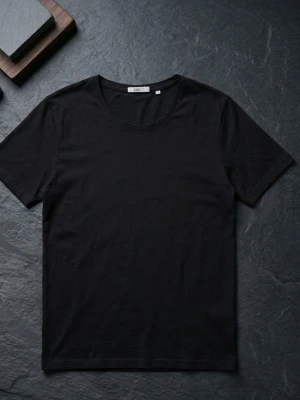 Svart basic t-shirt från Blëk - En klassisk svart t-shirt från Blëk i storlek XL. T-shirten har rund halsringning och korta ärmar, perfekt för en clean och enkel stil. Tillverkad i mjuk bomull som känns skön mot huden.