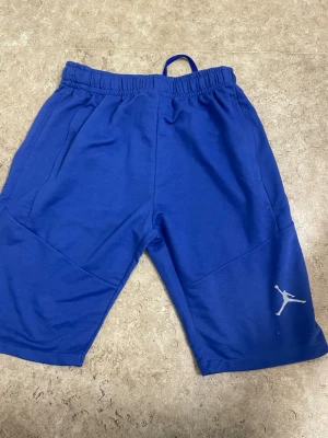 Kornblå shorts med resårmidja - Snygga kornblå shorts med elastisk midja och snörning. Perfekta för en avslappnad stil och tillverkade i mjukt bomullstyg som känns skönt mot huden. Enkla att matcha med t-shirt eller hoodie för en chill look.