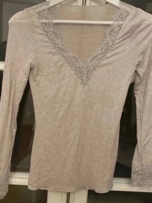 Intimissimi spets tröja  - Supersöt ljusgrå långärmad topp med v-ringning och spetsdetaljer både vid halsen och ärmsluten. Tunn och mjuk, perfekt att styla till jeans eller kjol. Enkel men ändå elegant look. Pris kan diskuteras💗 Den har inga defekter!💓💓