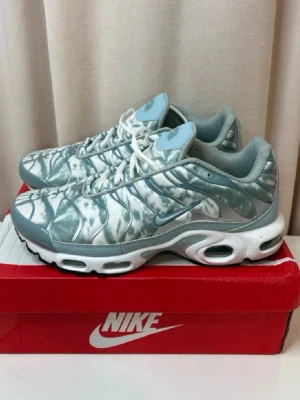Nike Air Max Plus blåvit sneakers - Nike Air Max Plus sneakers i blått och vitt med mönstrad mesh-överdel, vita snören och synliga Air-enheter i sulan. Swoosh-logga på sidan och detaljer i ljusblått. Skön vadderad insida och robust yttersula för bra grepp. Storlek 42 men passar även 41. Aldrig använda