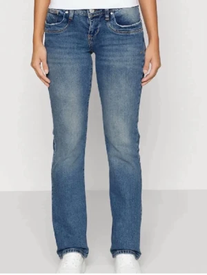 Blå bootcut jeans från LTB  - Säljer ett par klassiska blå bootcut jeans från LTB med fem fickor och normal midja. Jeansen har en snygg tvätt med lätt slitning på låren och raka ben som går ut lite nedtill. Perfekta till sneakers eller boots för en avslappnad look. Storlek 27/34