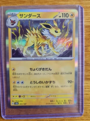 Jolteon Pokémonkort japansk holo - Japanskt Pokémonkort med Jolteon (サンダース), holografisk yta och eltema. Kortet har guldkant, färgstark bakgrund och är inplastat i skyddsfodral. Perfekt för samlare eller Pokémonfans.