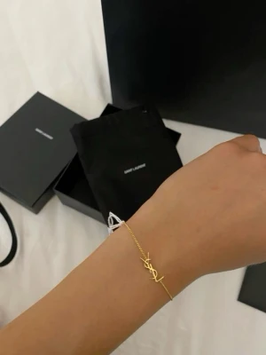 Guldigt armband  - Snyggt och stilrent armband med fin detalj. Tunt kedjearmband som ger en elegant och trendig look, perfekt för dig som gillar minimalistiska accessoarer med lyxig känsla. Box följer inte med.