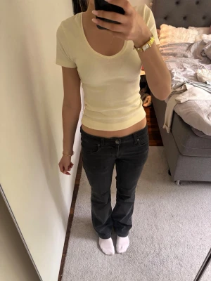 Svarta bootcut jeans med låg midja - Säljer ett par svarta bootcut jeans med låg midja och klassiska fickor. Jeansen har en snygg tvättad look. Perfekta till en avslappnad stil och passar till det mesta.