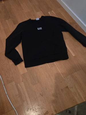 Svart sweatshirt från EA7 Emporio Armani - Mycket fin, litet svanker som inte syns när man bär tröjan (se sista bild) annars topp!