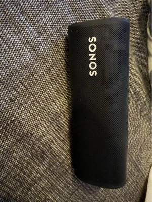 Sonos Roam 2 - Snygg och stilren bärbar högtalare från Sonos i svart. Högtalaren har en avlång, cylinderformad design med metallgaller och tydlig Sonos-logga. Perfekt för att ta med sig musiken överallt tack vare den kompakta formen och tåliga materialet.