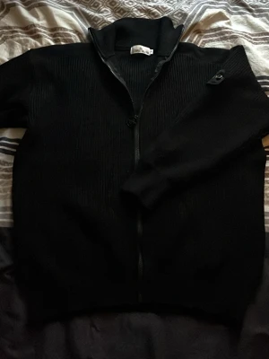 Stone Island Kofta - Säljer denna sjukt stilrena Stone Island kofta i storlek M/L. Använd ett fåtal gånger. Dock finns det ett litet stygnfel men inget stort! (Se sista bild)