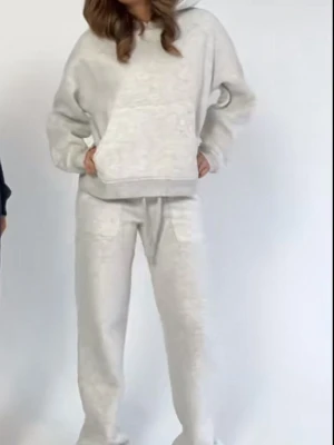 Ljusgrått loungewear-set med hoodie - Mysigt loungewear-set i ljusgrå färg med oversized hoodie och matchande byxor. Hoodien har stor ficka framtill och dragsko i huvan, byxorna har resår i midjan och raka ben. Perfekt för chill dagar hemma.