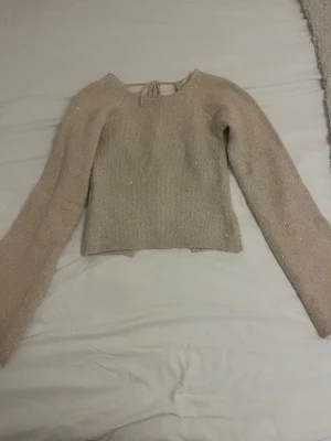 Stickad topp Gina - Supersnygg stickad topp med öppen rygg och glitter/paljetter från gina. Armarna går ut lite längst ut som blir en fin detalj. SLUTSÅLD Använd tre gånger, storlek xs💞