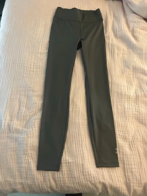 Mörkgrå träningstights från Lager 157 - Snygga mörkgrå träningstights från Lager 157 med hög midja och stretchigt material. Tightsen har en stilren design och logga på benet. Perfekta för gymmet eller löprundan.