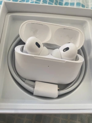 Apple AirPods Pro med laddningsetui - Säljer ett par Apple AirPods Pro i vitt med trådlöst laddningsetui. Hörlurarna har en stilren och kompakt design, silikonproppar för bra passform och brusreducering. Medföljer laddningskabel och extra öronproppar. Perfekt för musik, samtal och gaming. Kom gärna med bud!