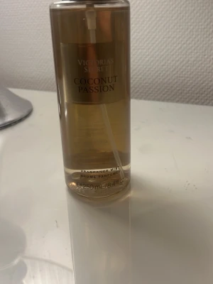 Victoria's Secret Coconut Passion mist - Fräsch body mist från Victoria's Secret i doften Coconut Passion. Flaskan är genomskinlig med guldiga detaljer och innehåller 250 ml. Doften har inslag av kokosmjölk och varma sandtoner för en solkysst och sensuell känsla.