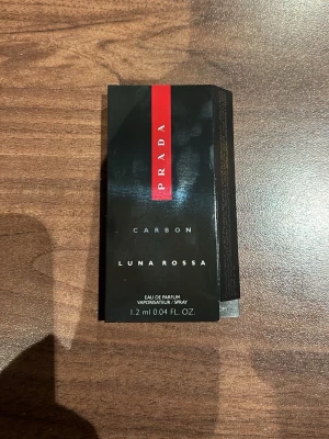 Prada Luna Rossa Carbon parfymprov - Säljer ett parfymprov av Prada Luna Rossa Carbon Eau de Parfum. Provet är 1,2 ml och kommer i en liten transparent sprayflaska med svart och röd kartong. Perfekt att testa en exklusiv doft från Prada.