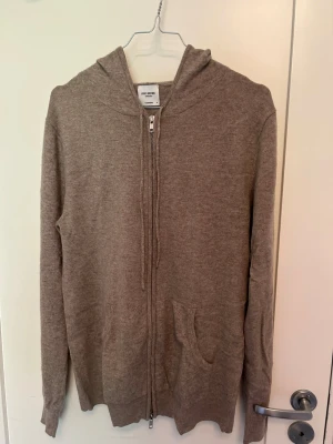 Beige zip-hoodie - Mysig beige hoodie med dragkedja framtill och huva. Tillverkad i mjukt material och har fickor på sidorna. Perfekt för en avslappnad stil och enkel att matcha med andra plagg. Nypris 2999 kr