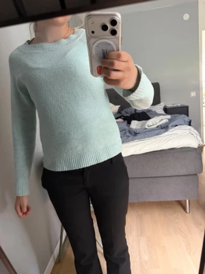 Ljusblå stickad tröja - Mysig ljusblå stickad tröja med rund halsringning och långa ärmar. Tröjan har ribbade muddar vid ärmslut och nederkant, vilket ger en klassisk och enkel look. Perfekt att matcha med jeans eller byxor för en avslappnad stil.