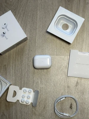 AirPods 2 pro med slad - Säljer ett par  AirPods Pro med vitt laddningsetui, extra silikonpluggar och laddkabel. Hörlurarna är trådlösa in-ear-modell i stilren vit färg och levereras med originalförpackning och tillbehör. Perfekta för musik, samtal och träning.