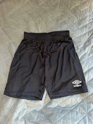 2 träningshorts  - Jag säljer två stycken umbro träningsshorts tillsammans, ett par vita och ett par svarta. Aldrig använda! 