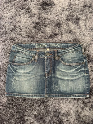 Vintage jeanskjol - Längd: 32 cm. Midja tvärsöver: 41 cm 