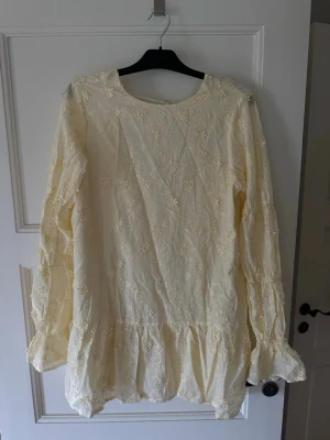 Ljusgul blommig klänning med volang - Ljusgul klänning från Nelly med broderade blommor och volang nertill. Klänningen är oanvänd o kommer med prislapp samt orginalförpackning.                     Vid snabb affär diskuteras priset! 
