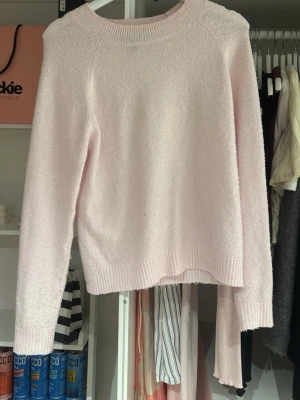 Ljusrosa stickad tröja Vero Moda - Mysig ljusrosa stickad tröja från Vero Moda i storlek XS. Tröjan har rund halsringning, långa ärmar och ribbade muddar vid ärmslut och nederkant. Perfekt för att hålla sig varm och snygg under kyliga dagar.