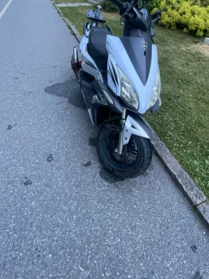 Silver och svart moped - Säljer en silver och svart moped med sportig design och breda däck. Mopeden har dubbla framlyktor, backspeglar och en bekväm sadel. Detaljer i rött och svart på sidan samt en avgas med metallfinish. Perfekt för dig som vill ta dig fram snabbt och smidigt. Klass 2 fungerar utmärkt bra 