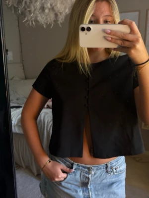Toppar  - Topp från Gina med slits vid magen samt knäppe upptill, helt oanvänd! 