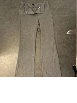 Grå kostymbyxor ZARA bootcut - Snygga grå kostymbyxor från zara med klassisk passform och lätt utsvängda ben. Byxorna har hällor för skärp, dold dragkedja och knapp framtill samt en bakficka. Perfekta för en stilren look. Passar längden  runt 165💕💕💕💕