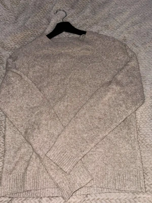 Beige/brun stickad tröja från Vero Moda - Säljer en beige stickad tröja från Vero Moda. Tröjan har rund halsringning, långa ärmar och ribbade muddar vid ärmslut och nederkant. Perfekt för lager-på-lager och enkel att matcha med jeans eller kjol.
