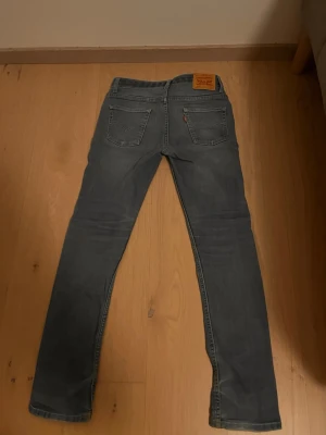Ljusblå Levi's 512  - Säljer ett par ljusblå jeans från Levi's med klassisk femficksmodell och raka ben. Jeansen har en snygg tvättad look och är tillverkade i mjuk denim. Perfekta för dig som gillar en avslappnad men stilren stil.
