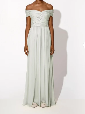Ljusgrön offshoulder långklänning - Elegant ljusgrön långklänning med offshoulder och draperad överdel. Klänningen har ett flytande fall och är tillverkad i ett tunt, mjukt material som ger en romantisk känsla. Perfekt för speciella tillfällen och sommarfester.