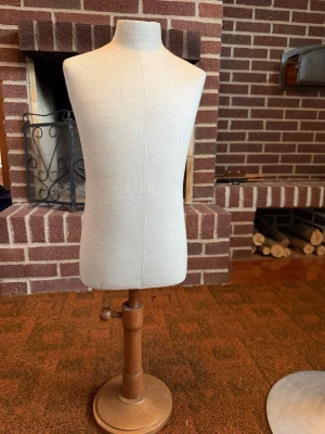 Beige provdocka i tyg och trä - 2 x Stilren provdocka i beige tyg med träfot och trästativ. Perfekt för att visa upp kläder eller accessoarer. Dockan har en klassisk form och är justerbar i höjd med en rund träbas. Passar både till dekoration och som hjälpmedel vid sömnad. 350 stycket 