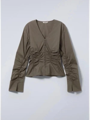 Grå v-ringad skjorta från Weekday - Trendig mörkgrön skjorta från weekday. Kjortan har rynkade detaljer framtill och vid ärmarna samt breda manschetter. Tillverkad i ett mjukt bomullstyg och har en figurnära siluett. Nypris:500, pris kan diskuteras 