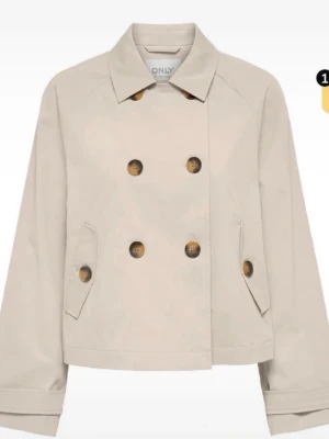 Beige trenchcoat från ONLY - Kort beige trenchcoat från ONLY med dubbelknäppning och stora bruna knappar. Klassisk krage och två snedställda fickor framtill. Jackan har en rak passform och är tillverkad i ett slätt tyg som ger en stilren look. Pris kan diskuteras 