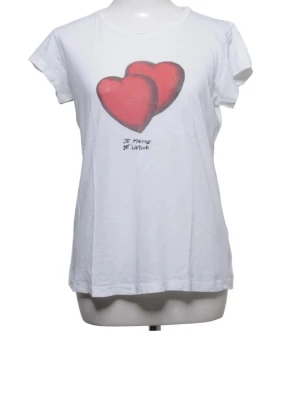 Vit t-shirt med röda hjärtan - Vit t-shirt med tryck av två stora röda hjärtan på bröstet och texten 'Je t'aime de Janvier' under. T-shirten har rund halsringning och korta ärmar. Perfekt för dig som gillar grafiska tryck och vill ha en enkel men söt look.