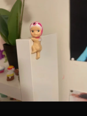 Sonny angel hippers looking back series sloth - En liten babydocka med rosa huva och vita vingar på ryggen. Jag har ingen aning om den är fejk men jag tror att den är det tyvärr 