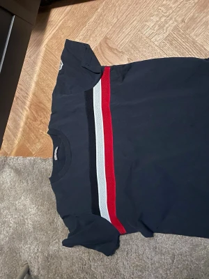 Moncler T-shirt  - Blå Moncler T-shirt. Storlek 14 år alltså typ xs/s. Passar allt från 168-176. Givetvis äkta. Köpt från vestiare därav ett äktighetsbevis. Pris är ej hugget i sten! Hör av dig vid minsta fråga. 