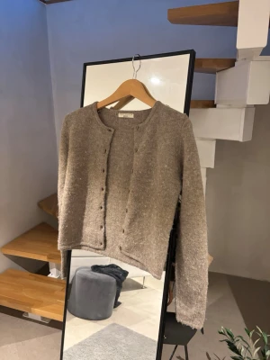 Beige kofta från Gina Tricot  - Mysig beige kofta från Gina Tricot i storlek XS. Koftan har rund halsringning, knappar framtill och är stickad i ett mjukt material. 