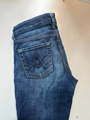Blå jeans från 7 For All Mankind - Snygga blå jeans från 7 For All Mankind med klassisk femficksdesign och broderad bakficka. Jeansen har slitningar vid fickan och är tillverkade i denim med en cool tvätt. Perfekta för dig som gillar en avslappnad och trendig look.