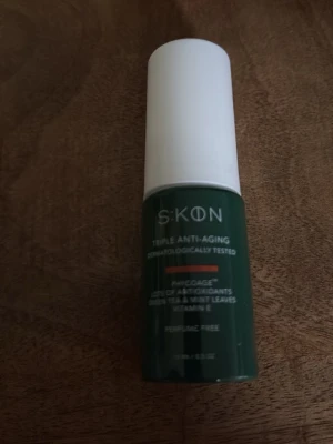 SKON Triple Anti-Aging serum - Grön flaska med vitt lock från SKON. Triple Anti-Aging serum med antioxidanter, vitamin E och extrakt från teblad och mynta. Dermatologiskt testad och parfymfri. Perfekt för dig som vill boosta din hudvårdsrutin.