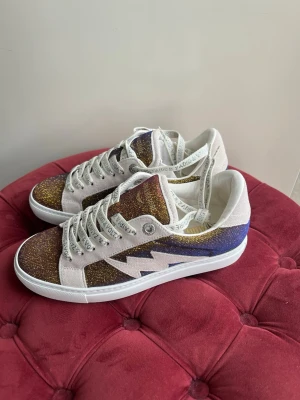 Zadig & Voltaire sneakers  - Säljer ett par helt nya Zadig Voltaire sneakers dam. Dom är endast använda en gång. Supersnygga och coola med glitterfärg som regleras beroende på ljus skon befinner sig i. Boxen finns och skickas såklart med❤️